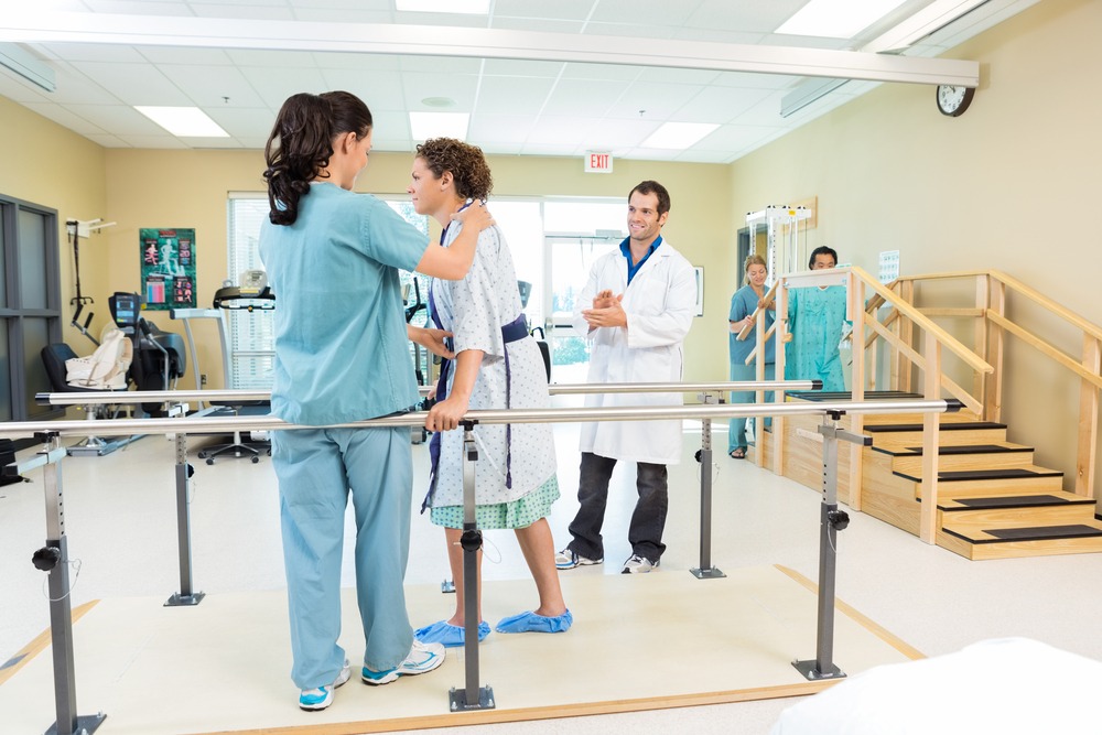 Mid,Adult,Female,Patient,Being,Assisted,By,Physical,Therapist,While